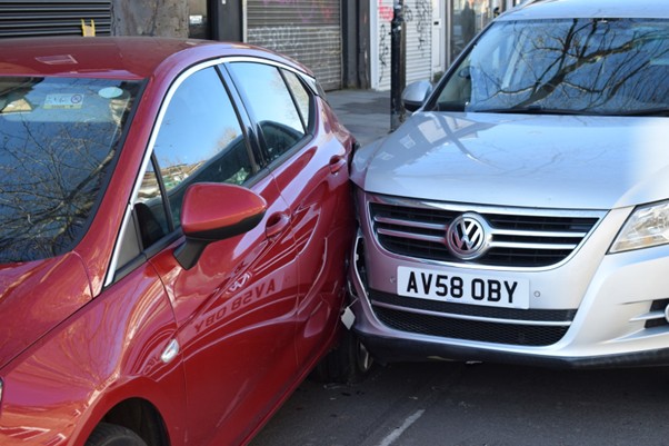 Image showing a silver car that has collided with a red car.