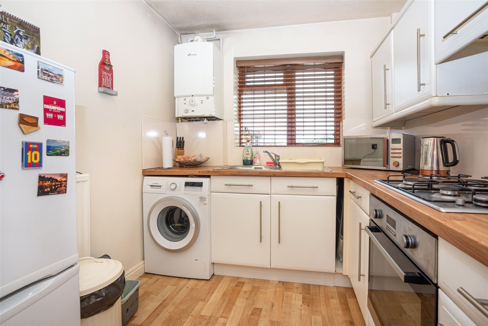 A kitchen with home appliances, including an oven, a washing machine, and a dishwasher.